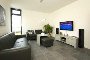a living room with a couch and a flat screen tv at Kapitaensweg 28 in Ostseebad Karlshagen
