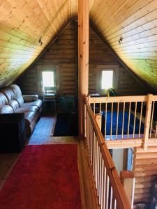 una sala de estar en una cabaña de madera con sofá en Romantic Cottage House, en Žužemberk