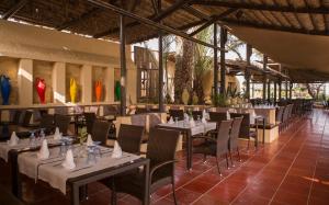 a restaurant with tables and chairs in a room at Africa Jade Thalasso in Korba