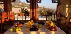a table with fruits and vegetables on it with a window at Mervin Hotel in Krujë