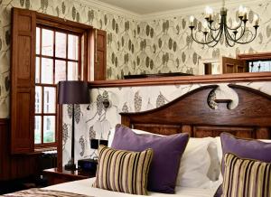 a bedroom with a bed and a chandelier at Lainston House in Winchester