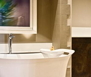 a bathroom with a bath tub with a sink at Lainston House in Winchester