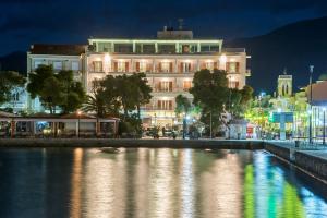 un edificio de noche junto a un río en Galini Hotel, en Itea