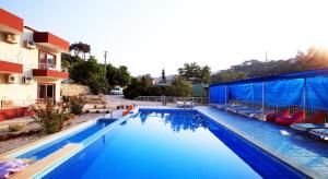 a large blue swimming pool next to a building at Rose Hotel B&B in Patara