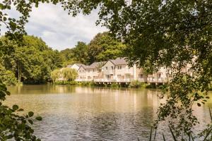 Village Pierre & Vacances Normandy Garden في برانفيل: منزل كبير على جانب البحيرة