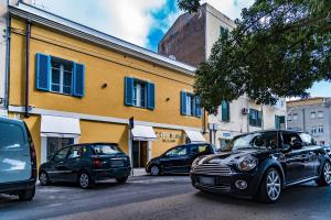 un gruppo di auto parcheggiate sul lato di una strada di Cafe Bleu Relais a Sassari