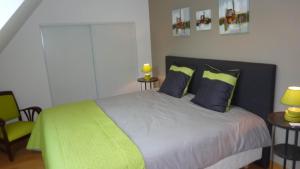 a bedroom with a bed with blue and green pillows at brest chambres d'hôtes in Brest