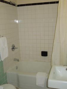 y baño con bañera blanca y lavamanos. en Red Lion Motel Southampton, en Southampton