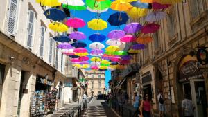 Um monte de guarda-chuvas pendurados numa rua da cidade. em Arles Holiday - Le Studio Chic em Arles