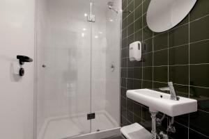 a bathroom with a shower and a sink at 2060 The Newton Hostel in Madrid