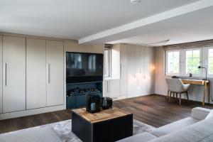 a living room with a couch and a tv at Le Bijou LQ80 Jacuzzi Penthouse in Zurich