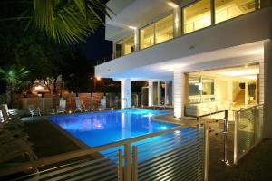 a swimming pool in front of a house at night at Hotel Fantasy in Riccione