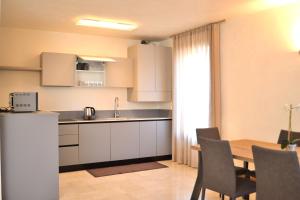 a kitchen and dining room with a table and chairs at Portico Oscuro Deluxe Apartment - centro città in Treviso