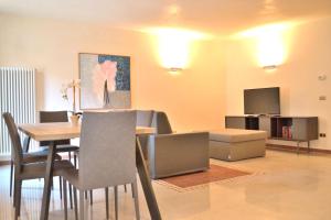 uma sala de estar com uma mesa de jantar e uma televisão em Portico Oscuro Deluxe Apartment - centro città em Treviso