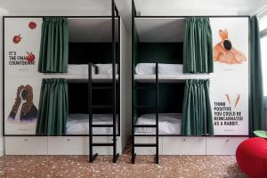 a bunk bed room with two bunk beds with green curtains at 2060 The Newton Hostel in Madrid