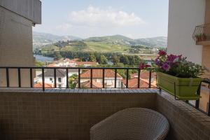 a balcony with a chair and a view of a valley at The Rooftop Suites in Peso da Régua