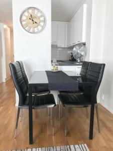 a kitchen with a black table and chairs and a clock at Antintorni Suite 17 in Pori