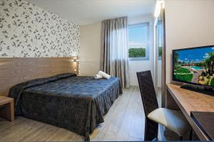 a hotel room with a bed and a flat screen tv at Relais Bellaria Hotel & Congressi in Bologna
