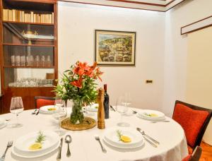 a dining room with a table with a vase of flowers at Villa Palma in Opatija