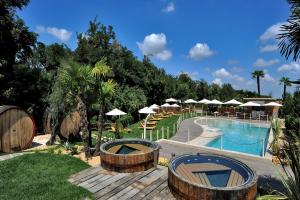 a resort with a pool and chairs and umbrellas at Relais Bellaria Hotel & Congressi in Bologna