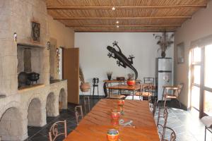 uma sala de jantar com uma mesa e uma lareira em Cheetah Lodge Guest House em Hartenbos