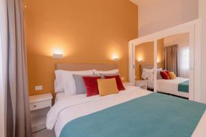 a bedroom with two beds with red and yellow pillows at Club Vista Serena in Maspalomas