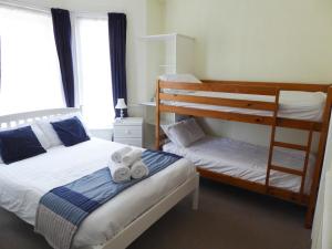 a bedroom with two bunk beds with towels on it at The Denewood in Sandown