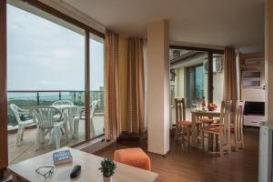 a living room with a view of a balcony at Aparthotel Hotel Prestige City II in Primorsko