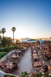 a group of people sitting at tables at a restaurant at Residence Club Marina Viva in Porticcio