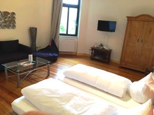 a living room with a white couch and a tv at HEINRICHs winery bed & breakfast in Langenlonsheim