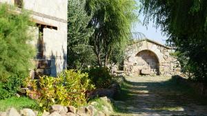 a stone building with an archway in a yard at Gokceada Surf Egitim Merkezi in Gokceada Town
