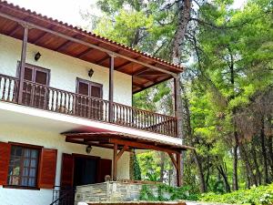 a large house with a deck on the side of it at Wood and Stone Villa in Sani Beach