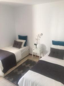 - une chambre avec 2 lits et une table avec un vase dans l'établissement Poseidons Pearl Duquesa, à Manilva