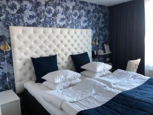 una camera da letto con un grande letto bianco e carta da parati blu di Sundbyholms Slott a Sundby