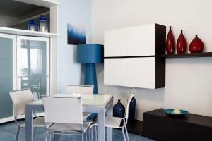 a dining room with a white table and chairs at Terrazza a mare Corallo in Marina di Ragusa