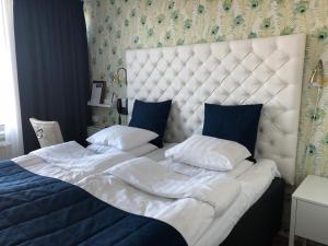 uma cama grande com lençóis brancos e almofadas azuis em Sundbyholms Slott em Sundby