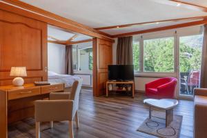 Habitación de hotel con cama y TV en Hotel Beau Rivage, en Zermatt