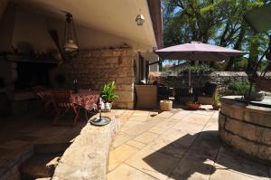 a patio with a table and an umbrella at Alla Cantina in Aurisina Case