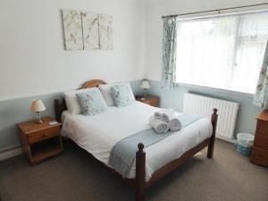 a bedroom with a bed with two towels on it at The Denewood in Sandown