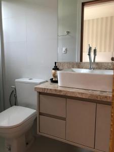 Un baño con lavabo blanco y inodoro. en Casa piscina próxima praia, en Florianópolis
