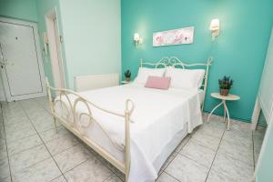 a bedroom with a white bed with a blue wall at Villa Sophia in Mytikas