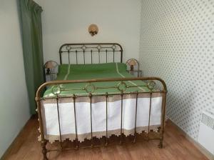 an old metal bed in a corner of a room at Lou Filadour rez de chaussée 5 personnes in Jausiers