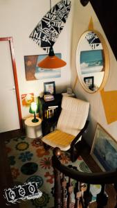 a living room with a chair and a mirror at h2oholidays for you in Capbreton