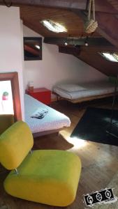 a room with two beds and a green chair at h2oholidays for you in Capbreton