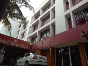 a white car parked in front of a building at Hotel Silver Sand in Trivandrum