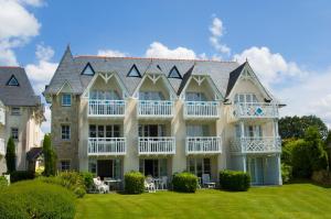 an exterior view of a large house with a lawn at Residence Cap Glenan - maeva Home in Bénodet