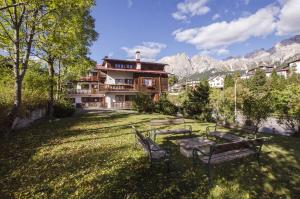 a group of benches in a yard with a house at Lungoboite 14 - Cortina in Cortina dʼAmpezzo
