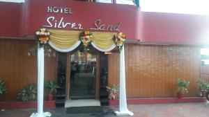 un cartello di sabbia argentata di fronte a un edificio di Hotel Silver Sand a Trivandrum