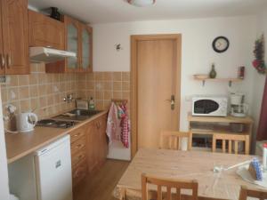 a small kitchen with a table and a microwave at Apartman Hrabice in Vimperk