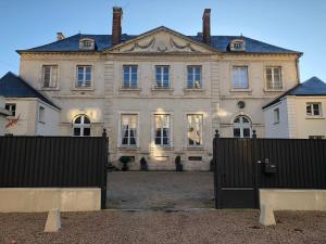 una vecchia casa con una recinzione di fronte di Castel Saint-Léonard a Falaise